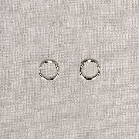 Two silver-colored round metal spring gate clips for bags on a textured grey background.