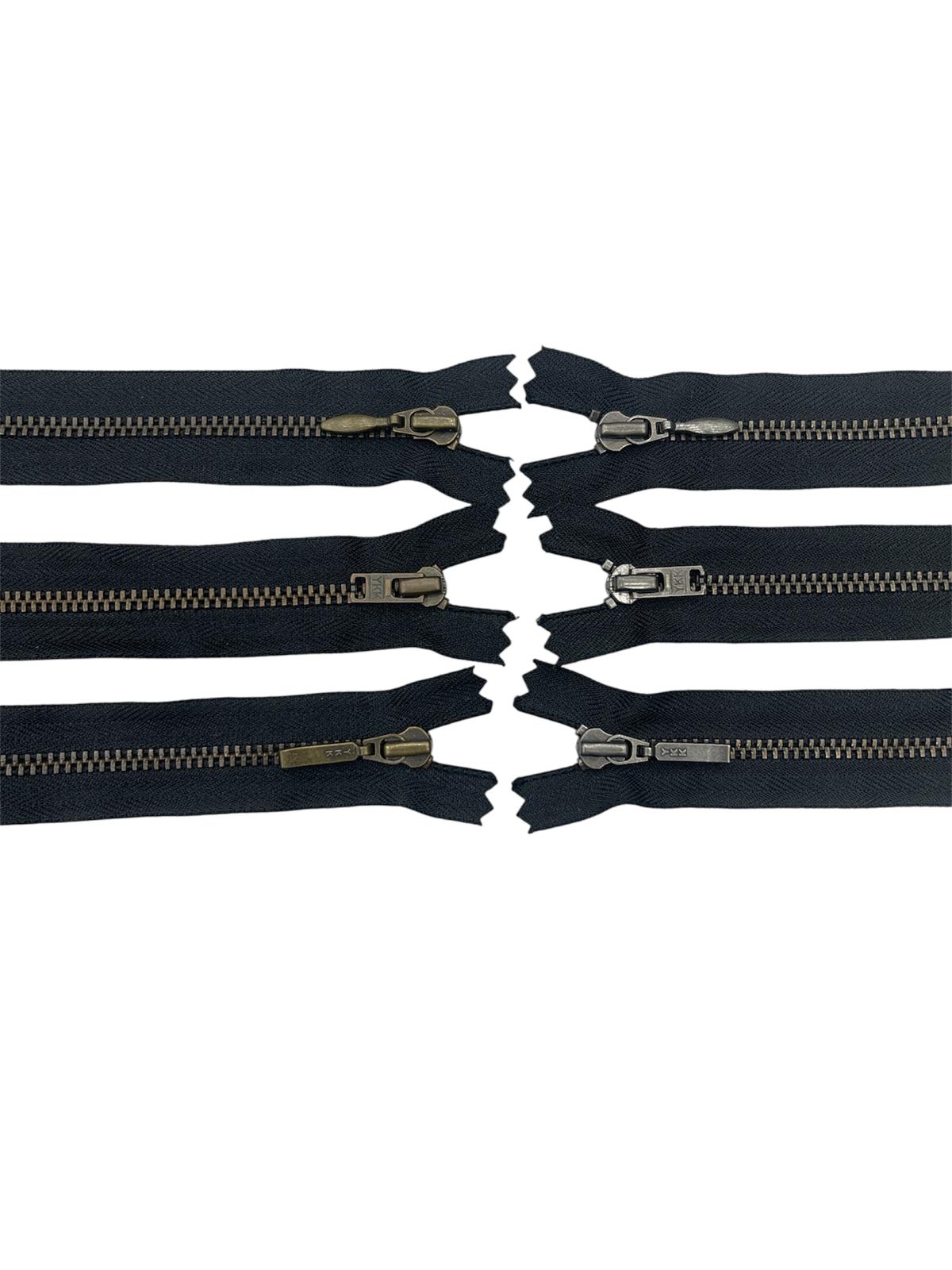 Six YKK size 3 brass metal closed-end black zippers with various slider styles on a white background.