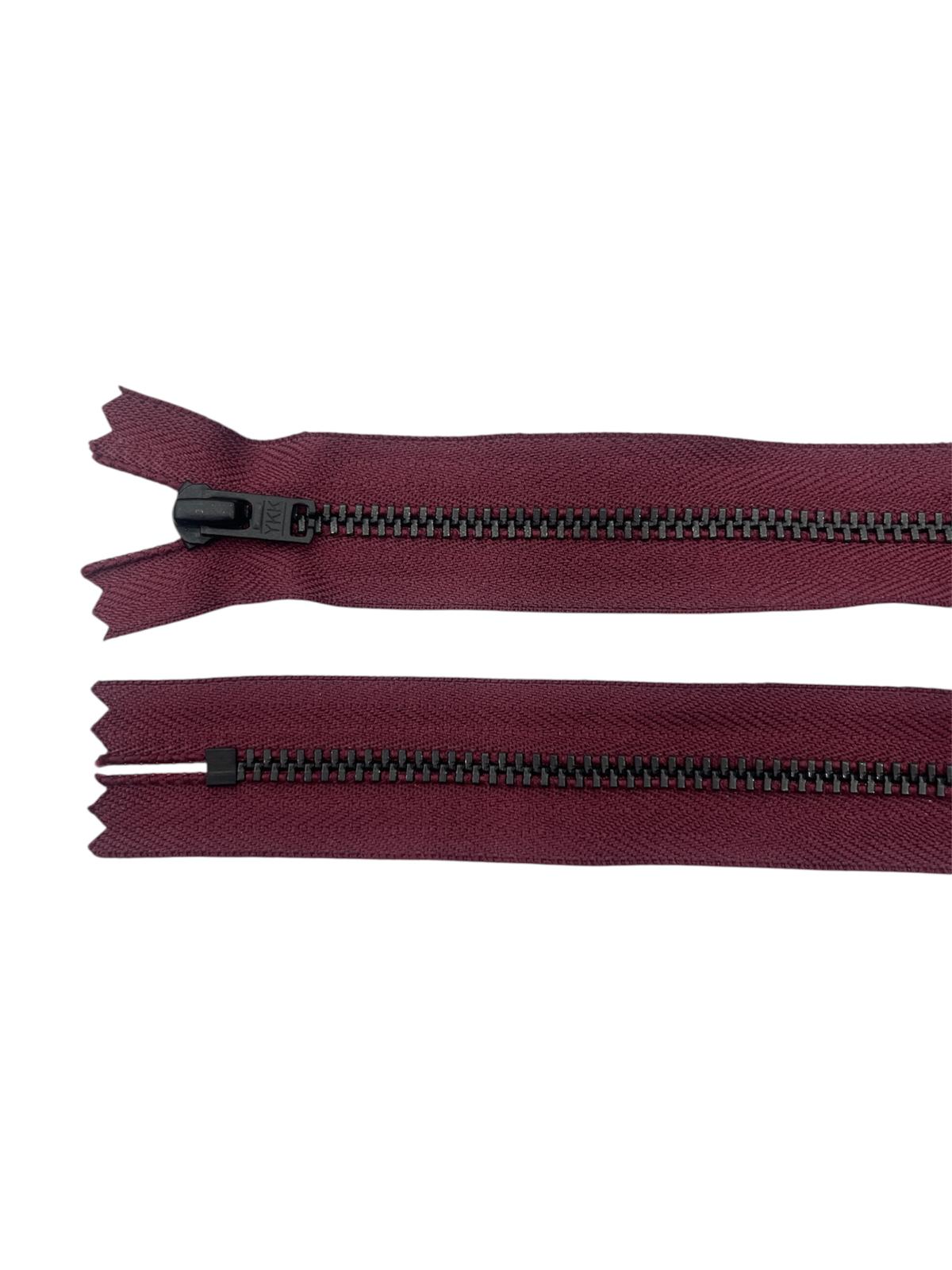 Two burgundy YKK zippers with black metal teeth on a white background.