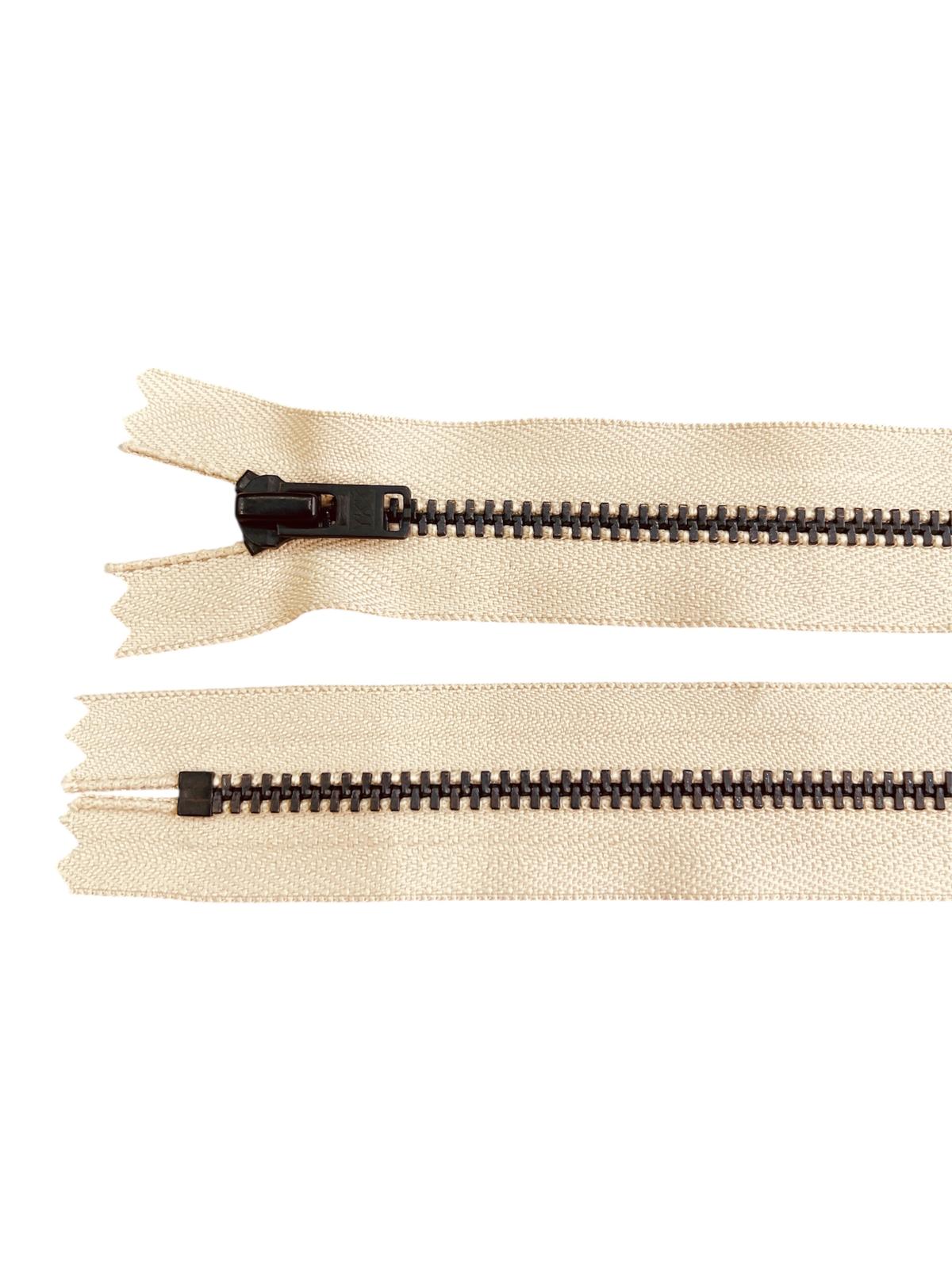 YKK size 3 black metal closed-end zipper on a cream fabric.