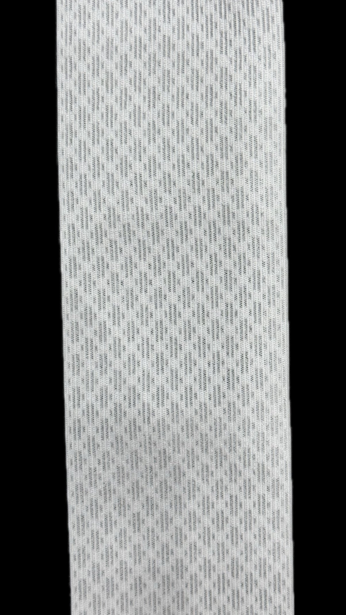 Close-up of a white mesh stretch belt with a textured, diamond-patterned weave.