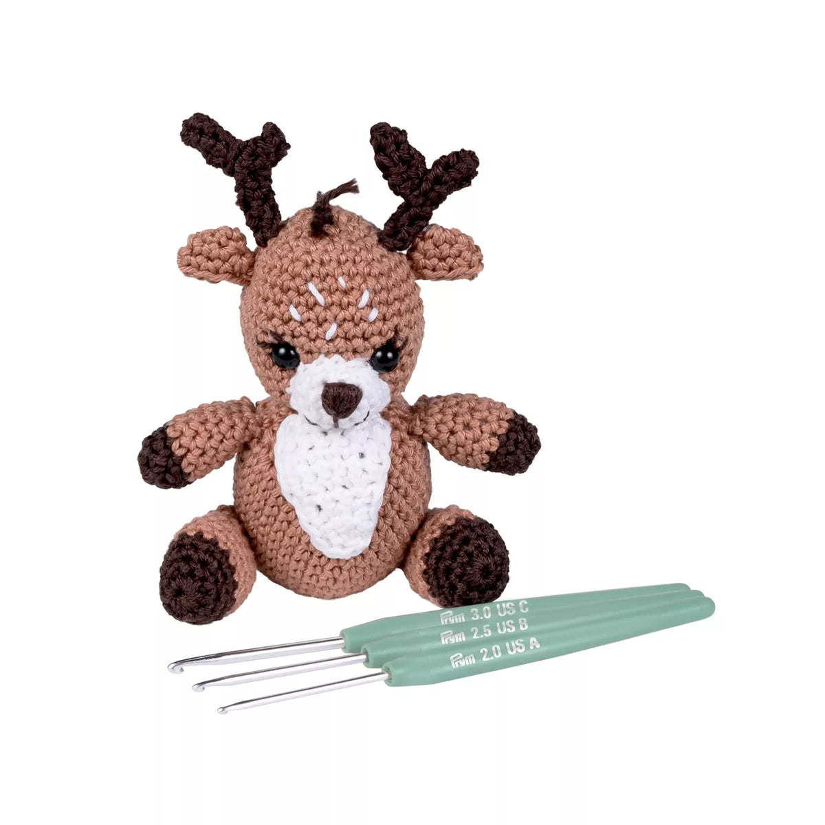 Three linden green Prym amigurumi crochet hooks next to a small crocheted brown reindeer.
