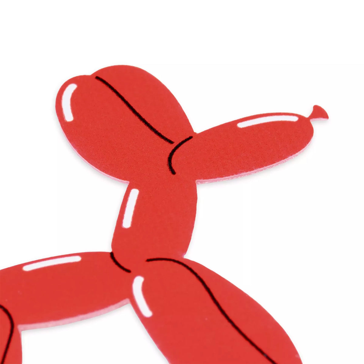 Close-up of a red self-adhesive balloon poodle appliqué with white highlights and black outlines.
