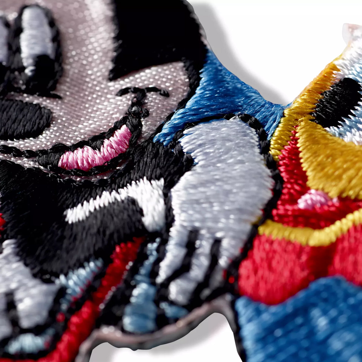 Close-up of a colorful embroidered iron-on appliqué featuring Mickey and Minnie Mouse.