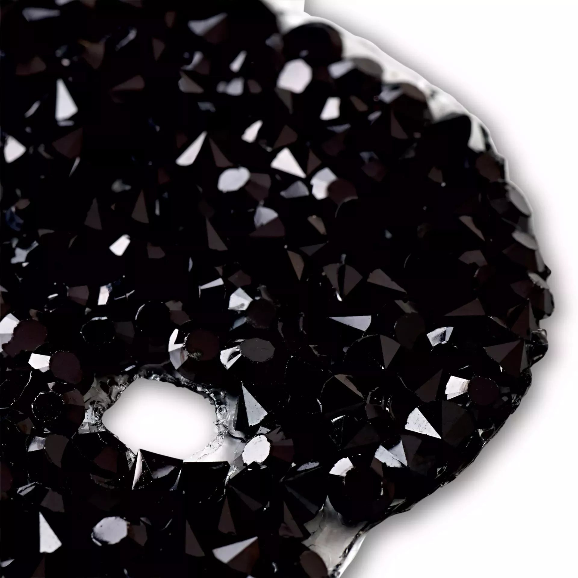Close-up of a black skull and crossbones iron-on patch featuring faceted, sparkling rhinestones.