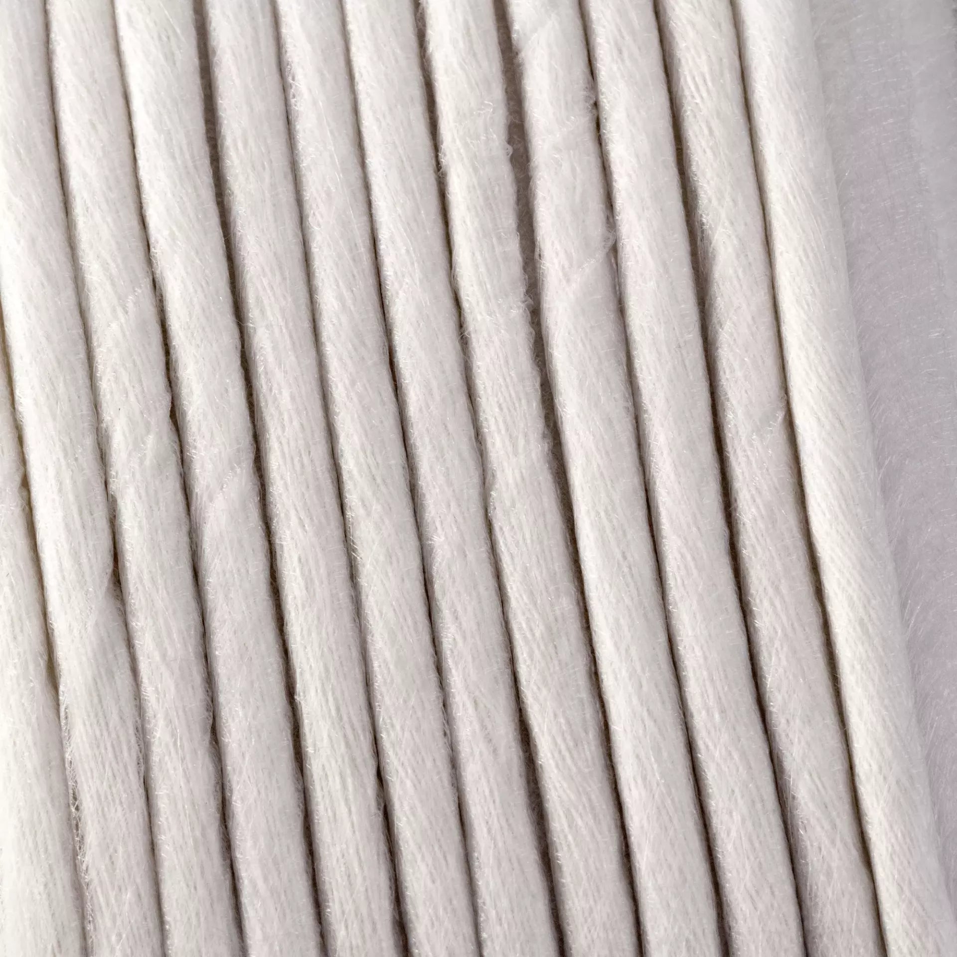 Close-up of white 6mm fusible piping interfacing cord with a soft, fibrous texture.