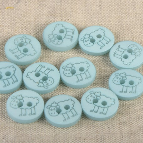 A collection of light blue 15mm polyester sewing buttons featuring a whimsical sheep design.