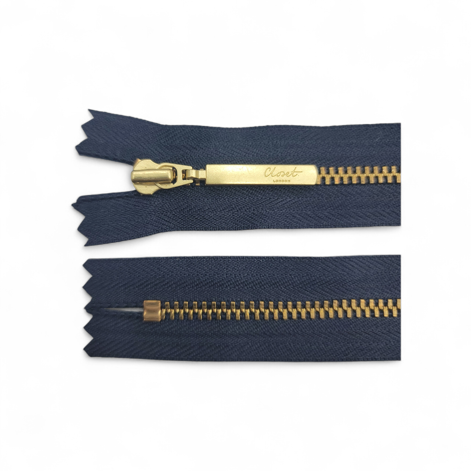 YKK size 3 closed end gold metal zip with navy fabric.