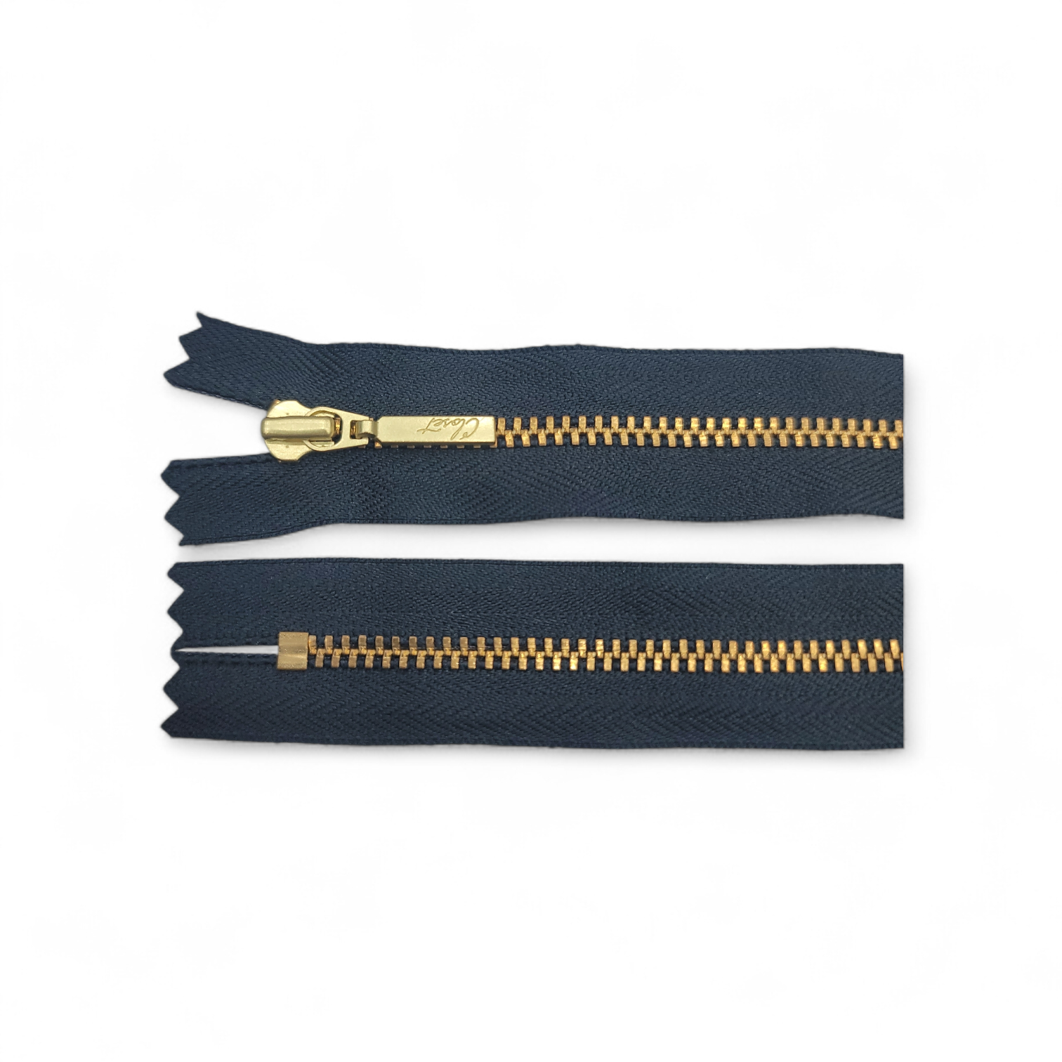 YKK size 3 closed end gold metal zipper on dark fabric.