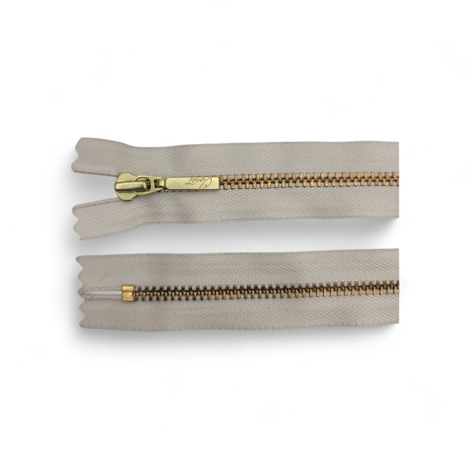 YKK size 3 closed end gold metal zip with beige tape.