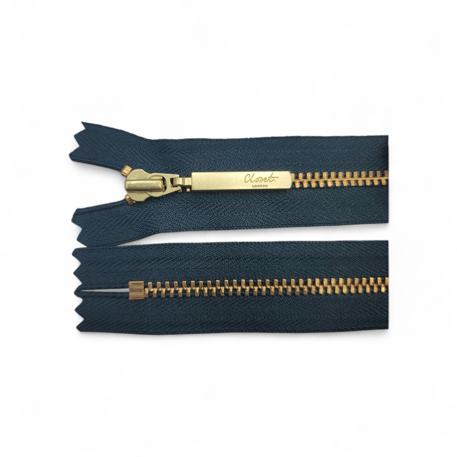 YKK size 3 closed end gold metal zip with dark blue fabric.