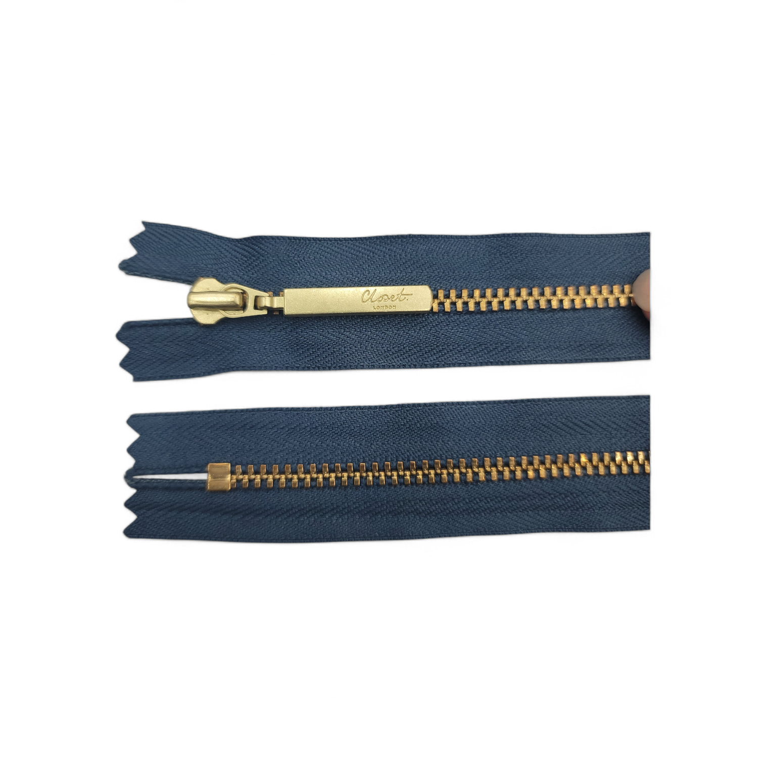 YKK size 3 closed end gold metal zipper on navy fabric.