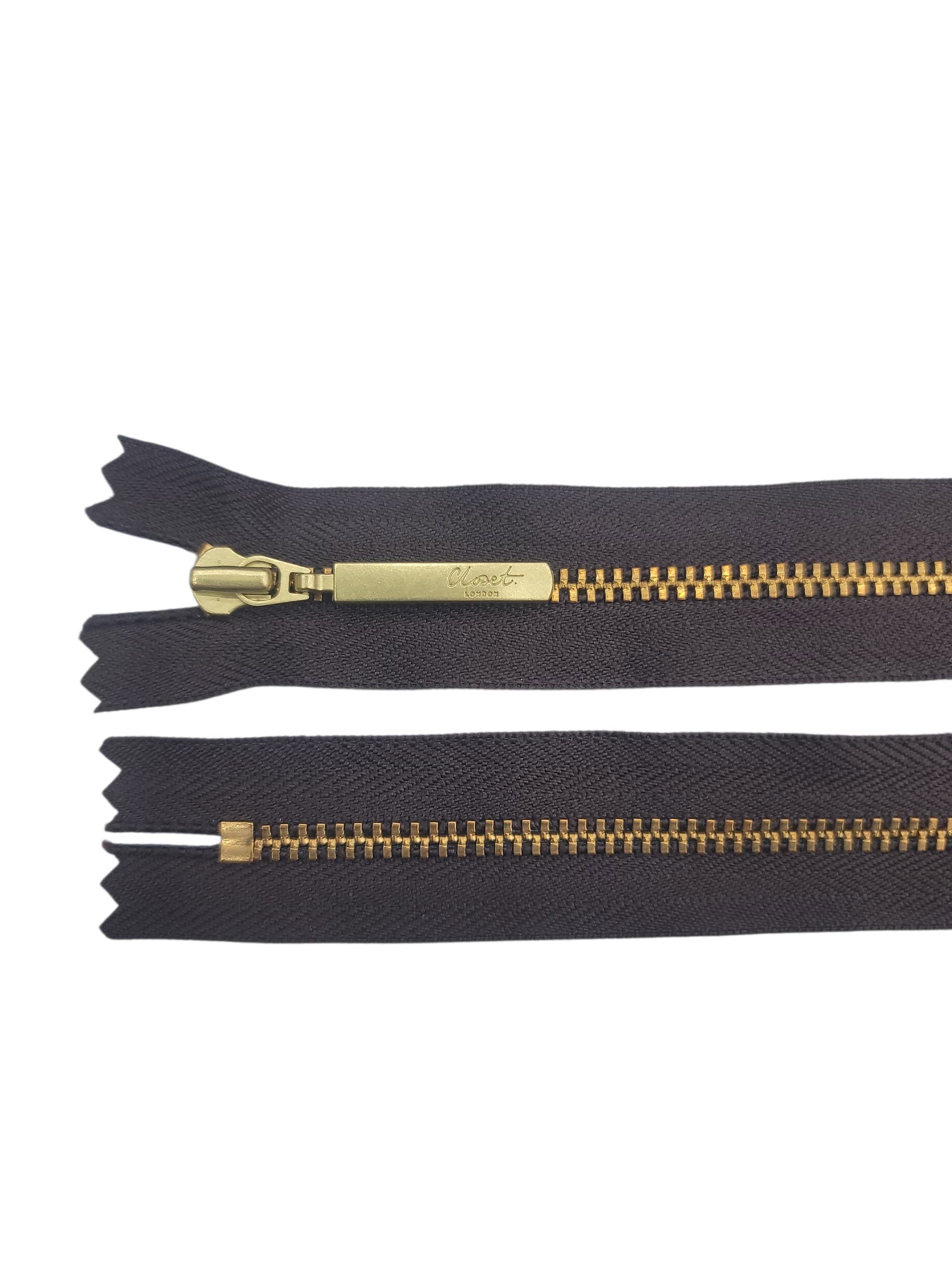 YKK size 3 closed end gold metal zipper with black tape.