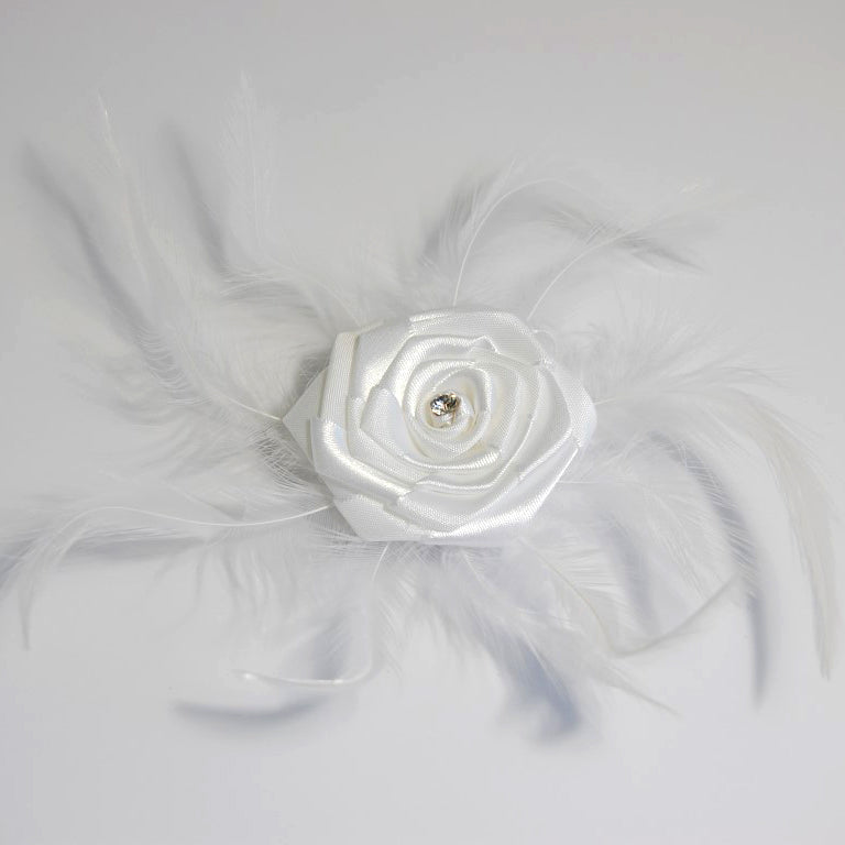 White ribbon rose with a central diamante and surrounding feathers, featuring a pin clip back.