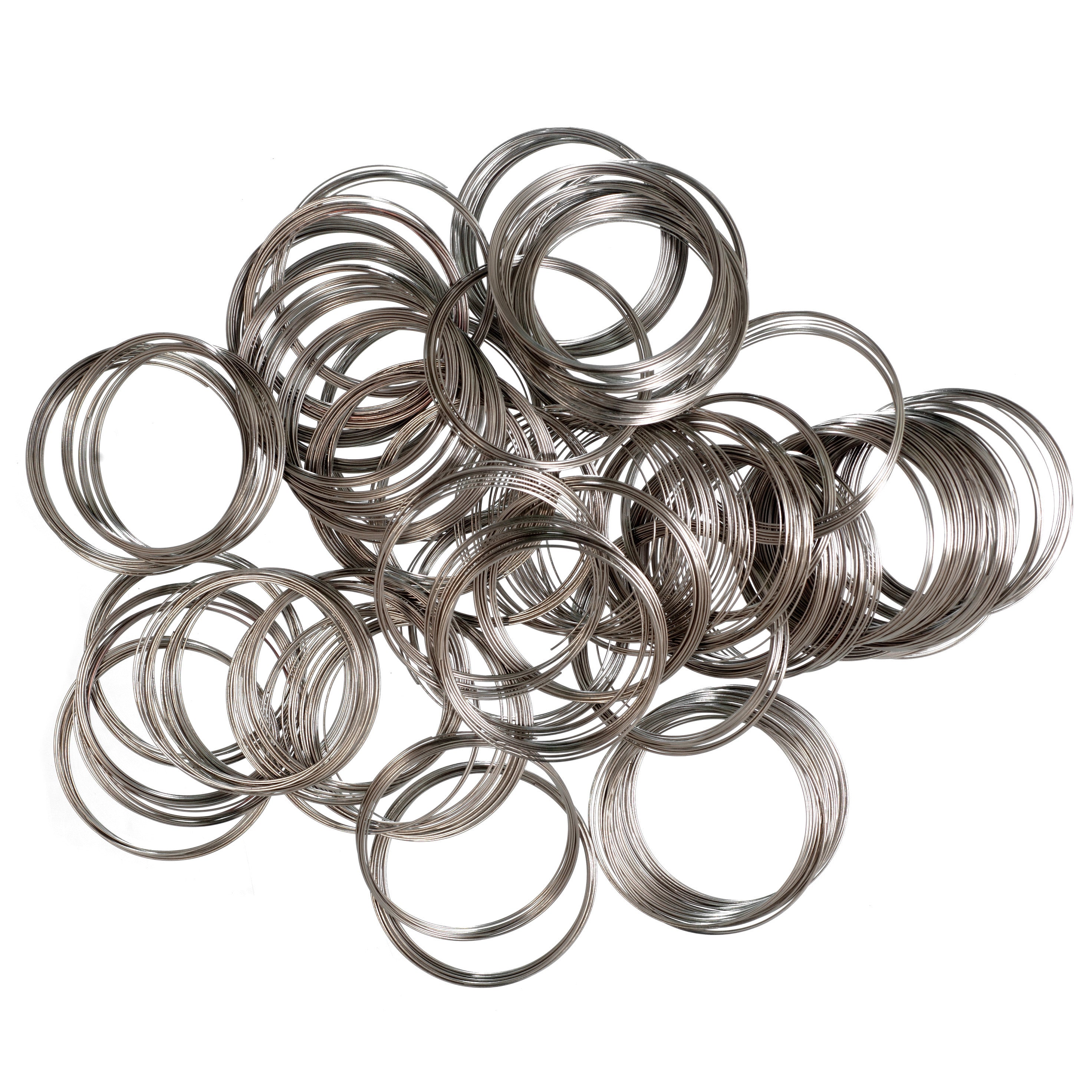 A pile of silver-colored memory wire rings for jewelry making, 5cm diameter.