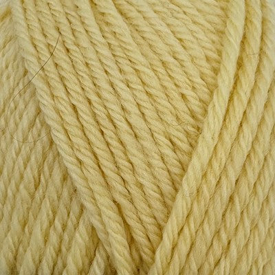 Close-up of Stylecraft Naturals Pure Wool DK yarn in a pale buttermilk yellow shade.