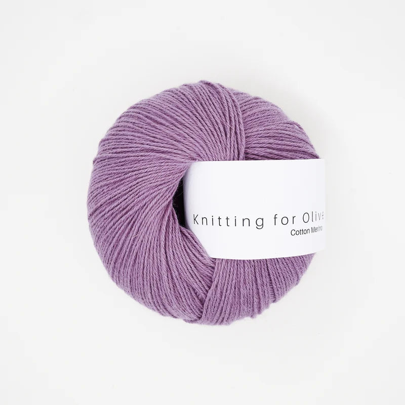 A ball of Knitting for Olive Cotton Merino yarn in a soft purple color with a white paper label.