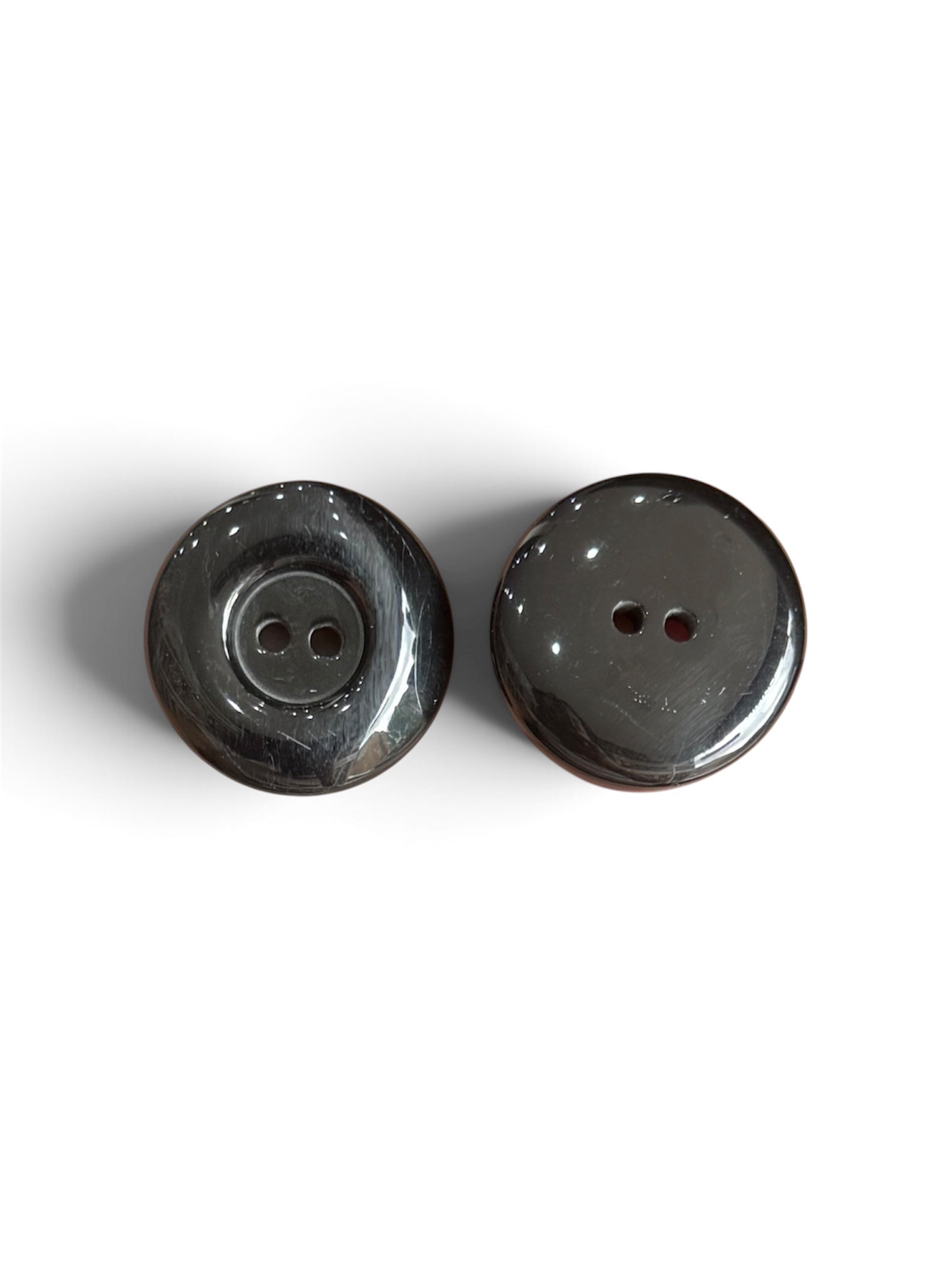 Two 30mm black resin 2-hole flat buttons with a polished, high-gloss finish on a white background.