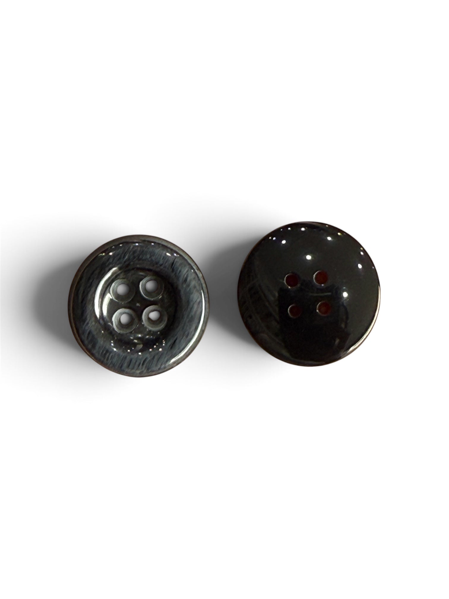 Two black resin 4-hole round sewing buttons, one showing the front and one showing the back.