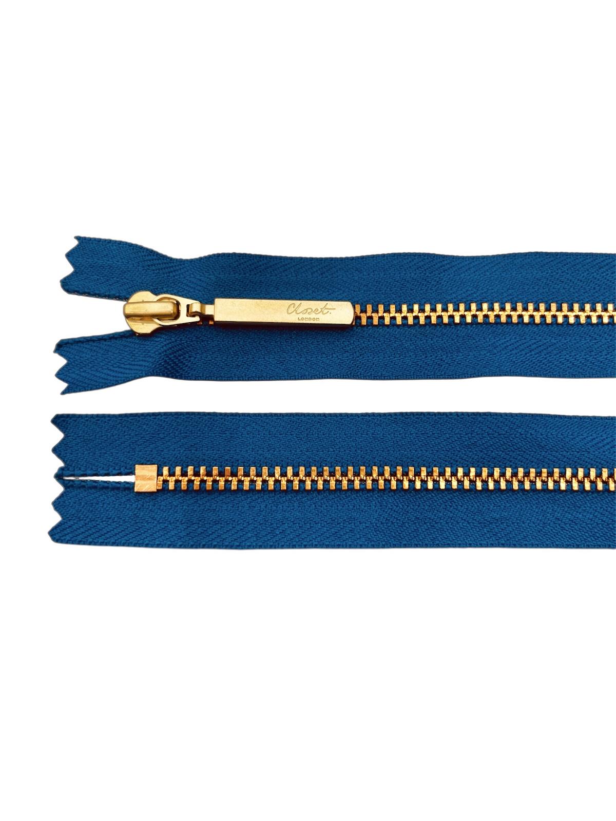 YKK size 3 closed end gold metal zip with blue fabric.