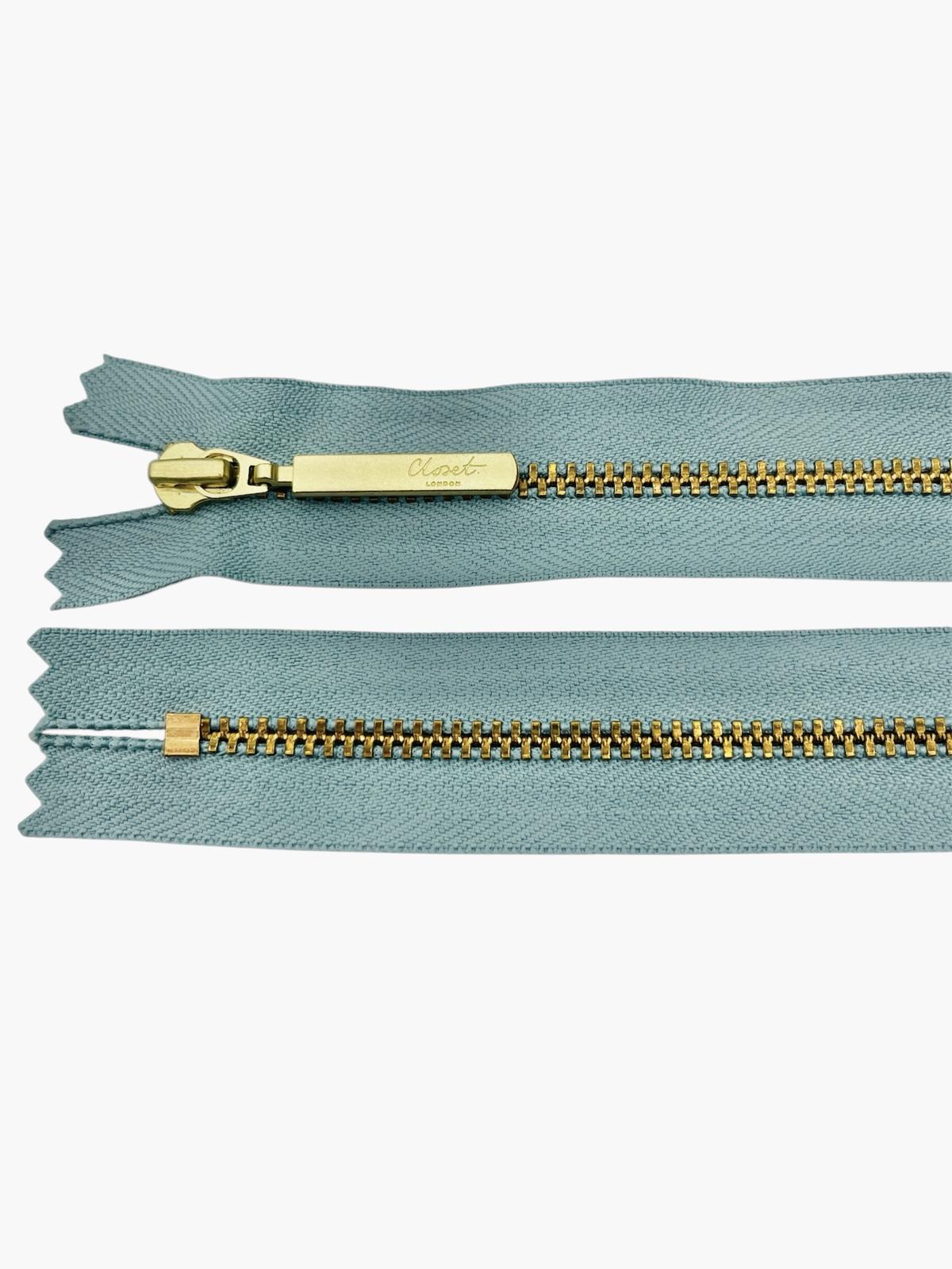 YKK size 3 closed end gold metal zip with light blue fabric.