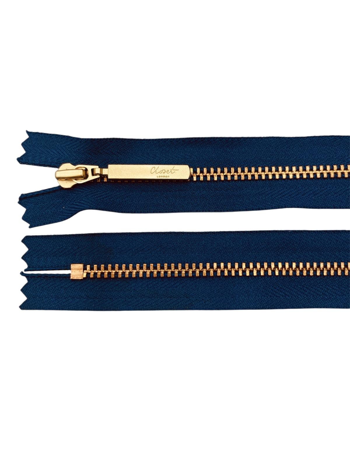 YKK size 3 closed end gold metal zip with navy blue fabric.