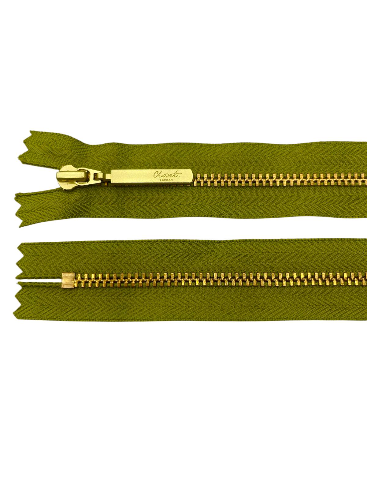 YKK Size 3 closed end gold metal zip with green tape.