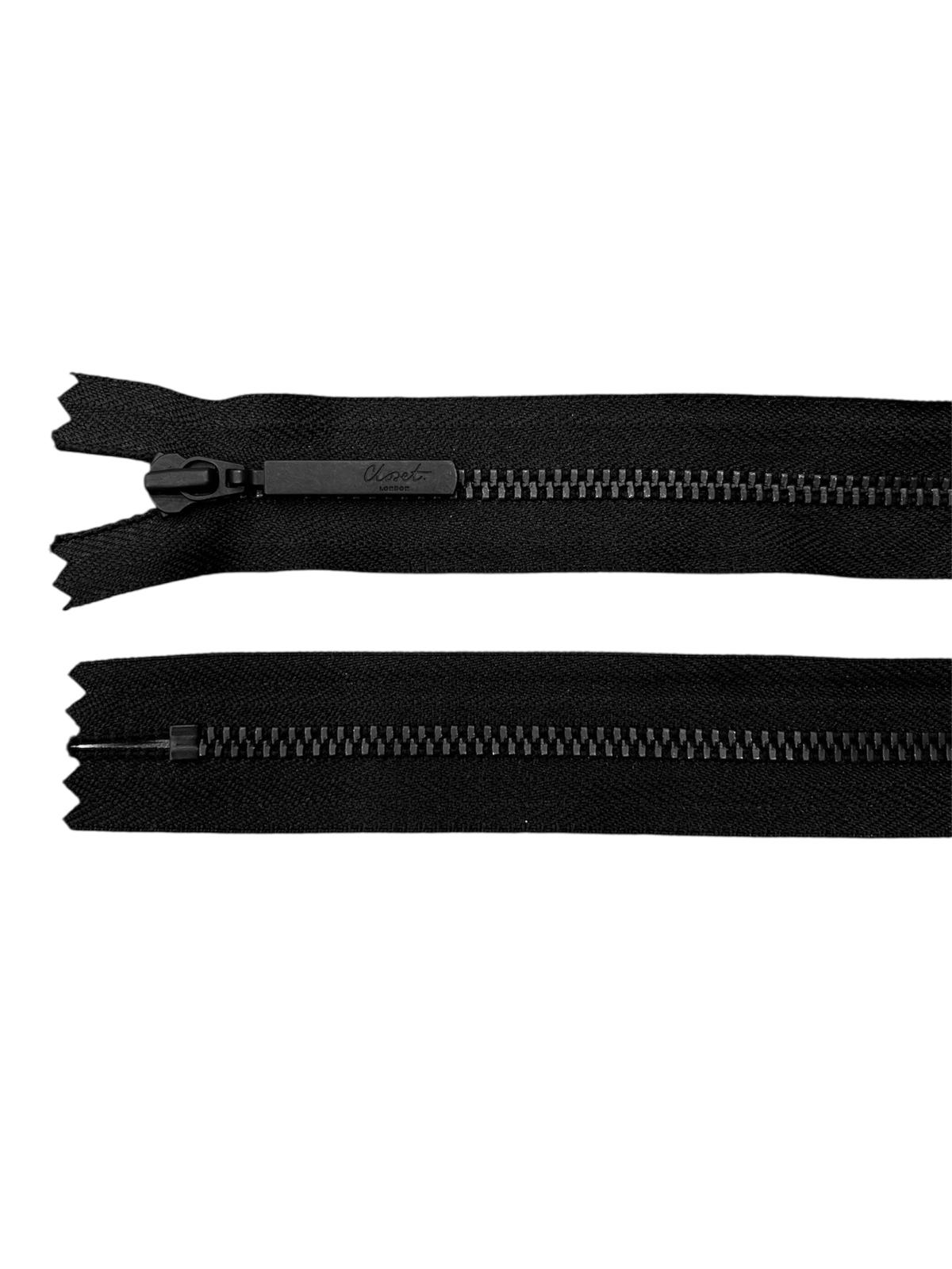 Black YKK metal zipper with a closed end and a branded pull tab.