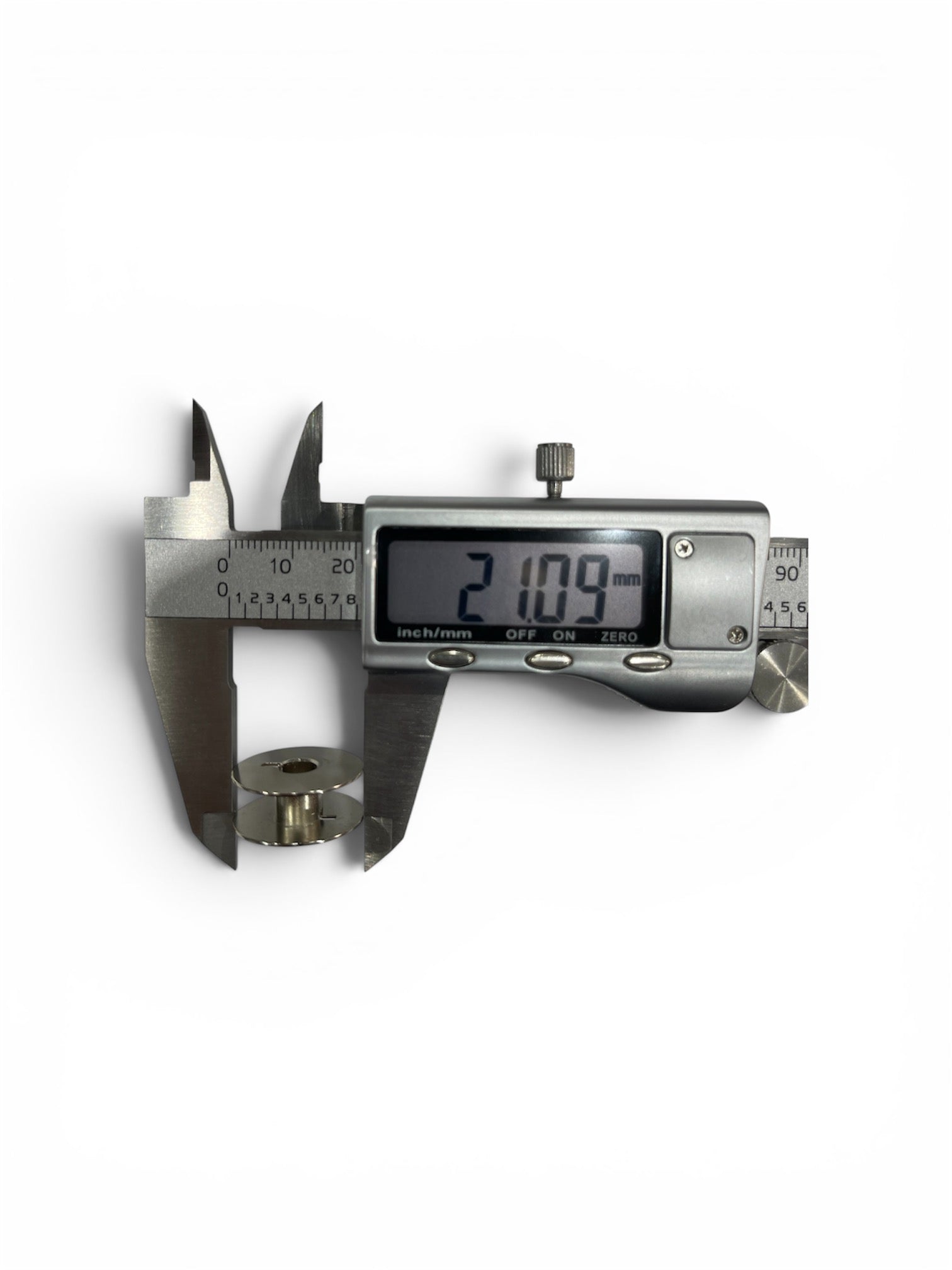 Janome Class 15 metal bobbin measured with a digital caliper showing a 21.09 mm diameter.
