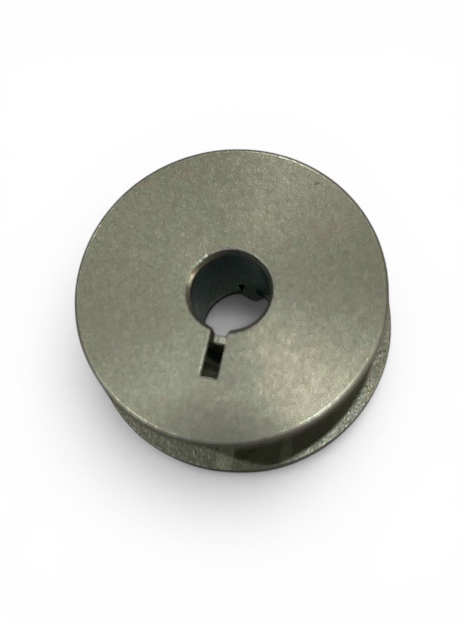 Janome HD9 Version 1 and 1600P genuine jumbo metal bobbin with center hole and keyway notch.