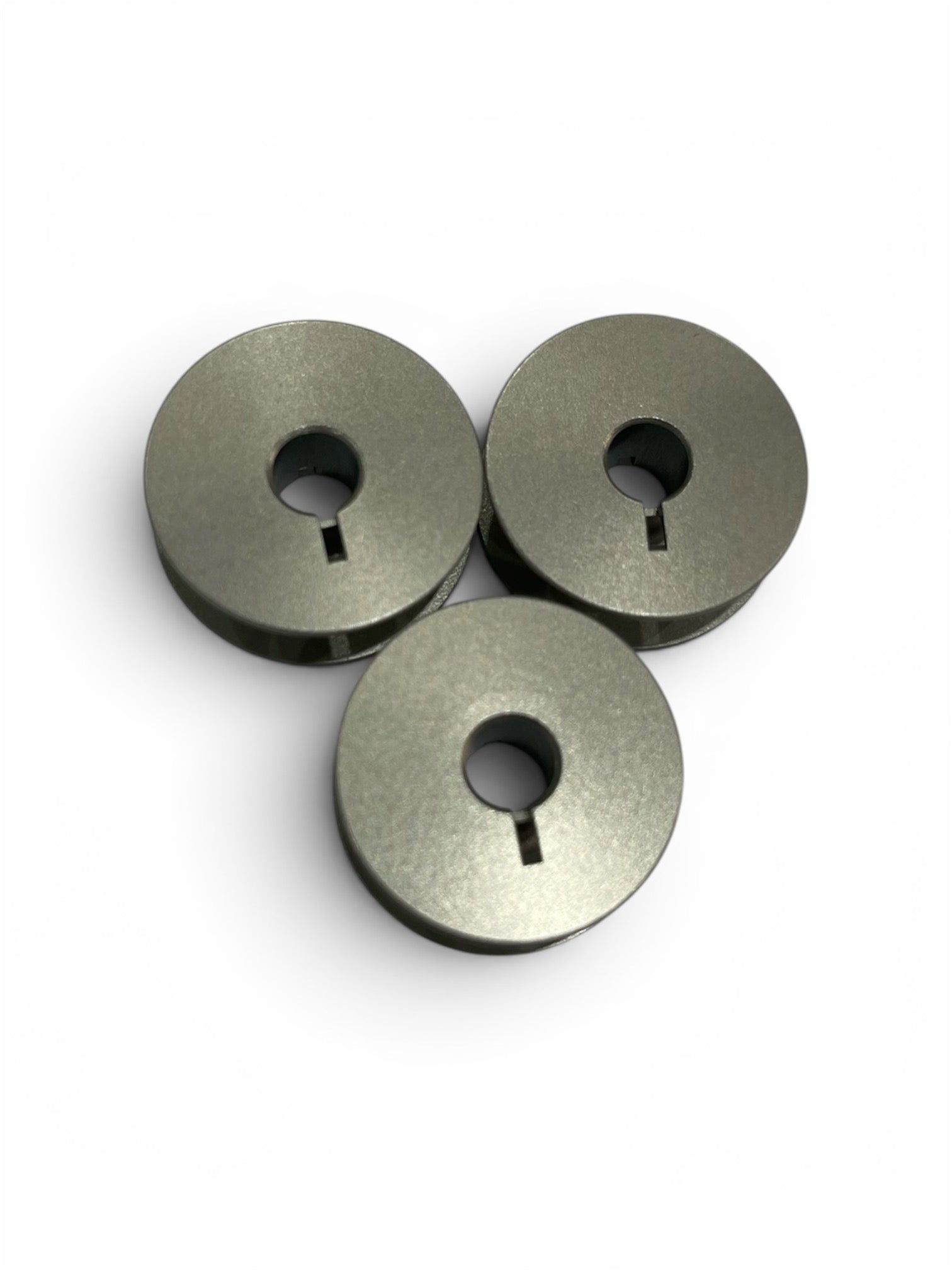 Three Janome jumbo metal bobbins for HD9 V1 and 1600P sewing machines on a white background.