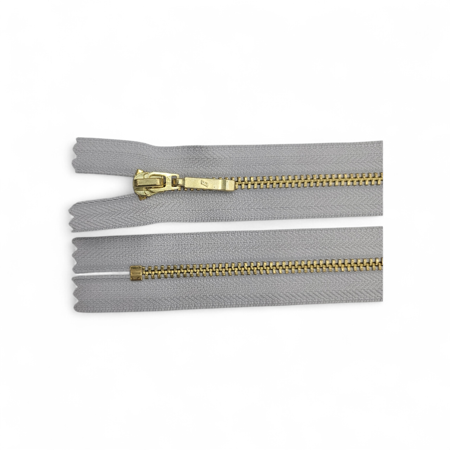 YKK size 3 closed end gold metal zip with grey tape.