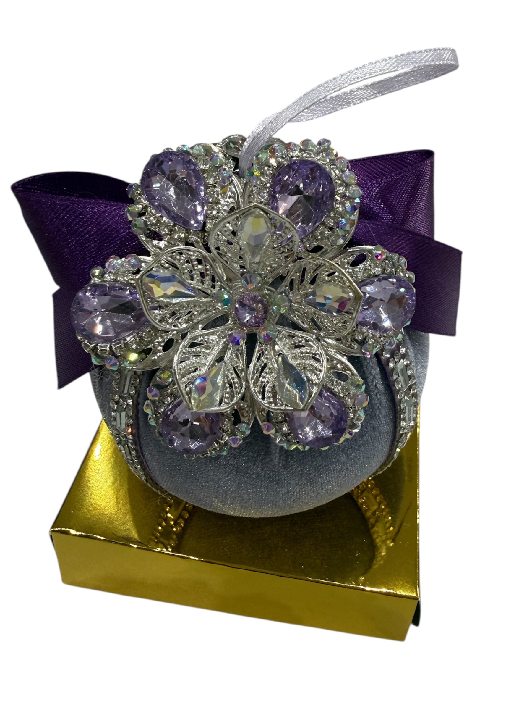 Round hand-embroidered Christmas ornament with purple gems and a gold box.