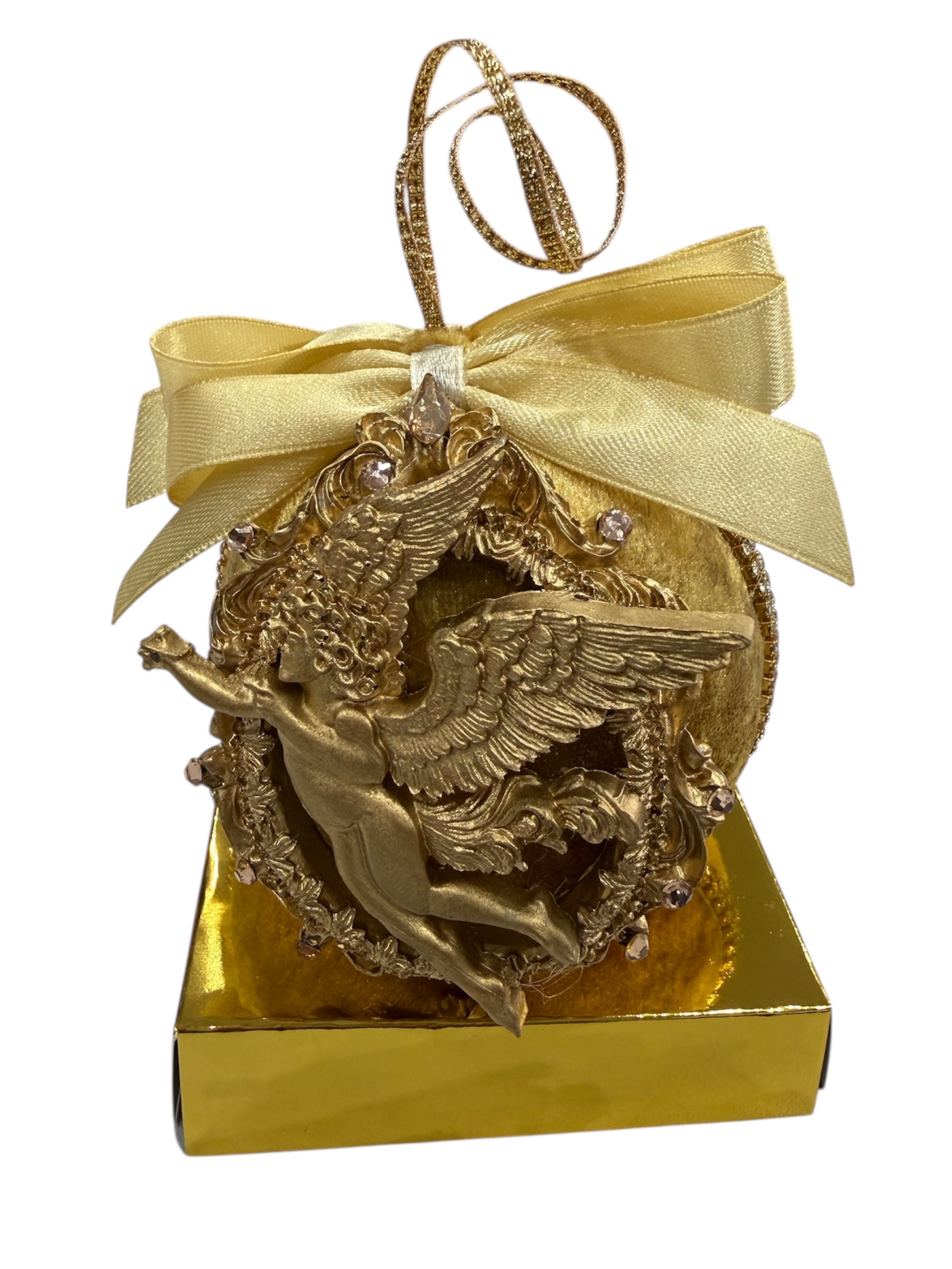 Gold angel ornament with a yellow ribbon and bow on a gold box.
