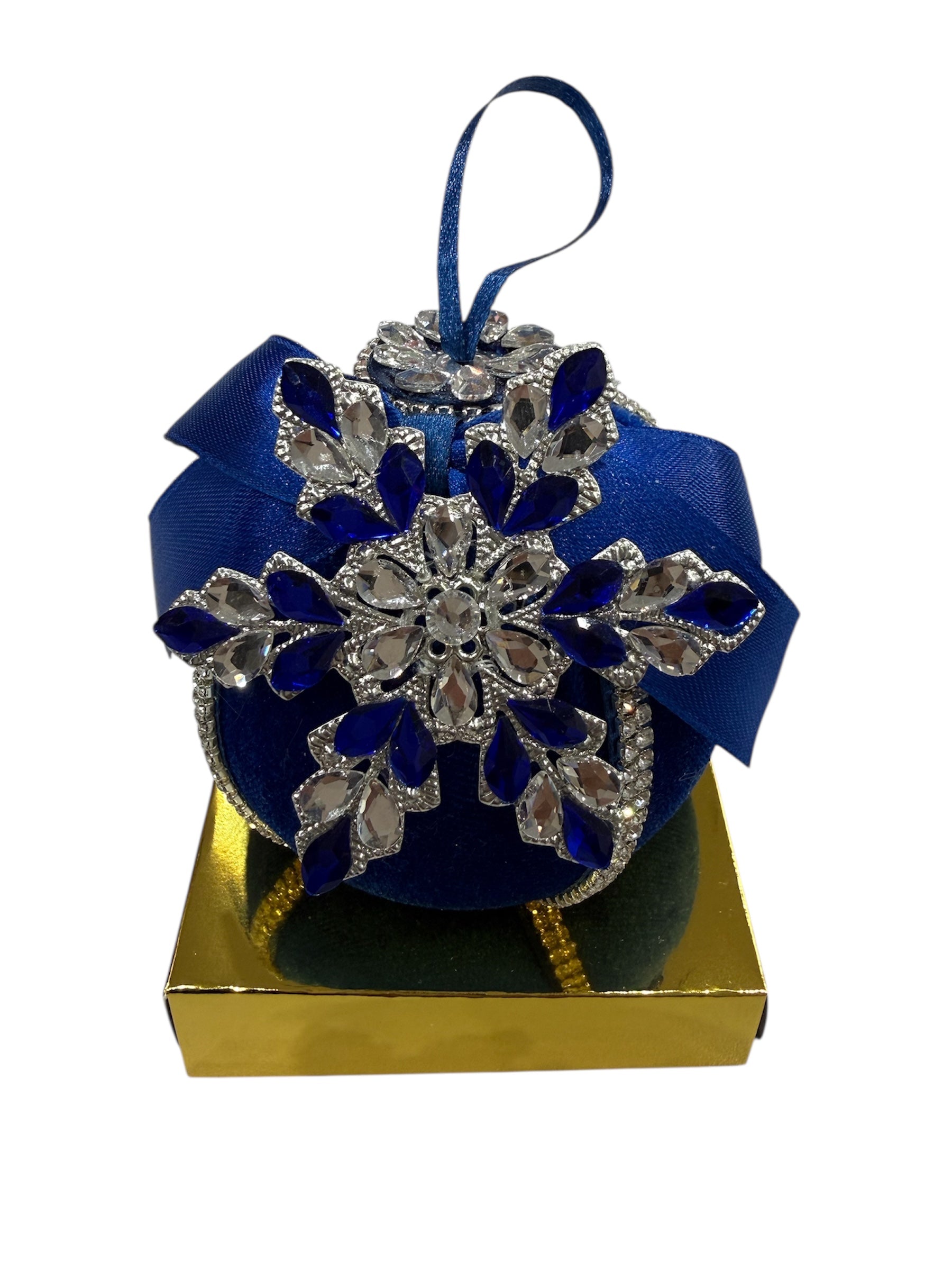 Blue velvet Christmas ornament with snowflake embellishments on a gold box.