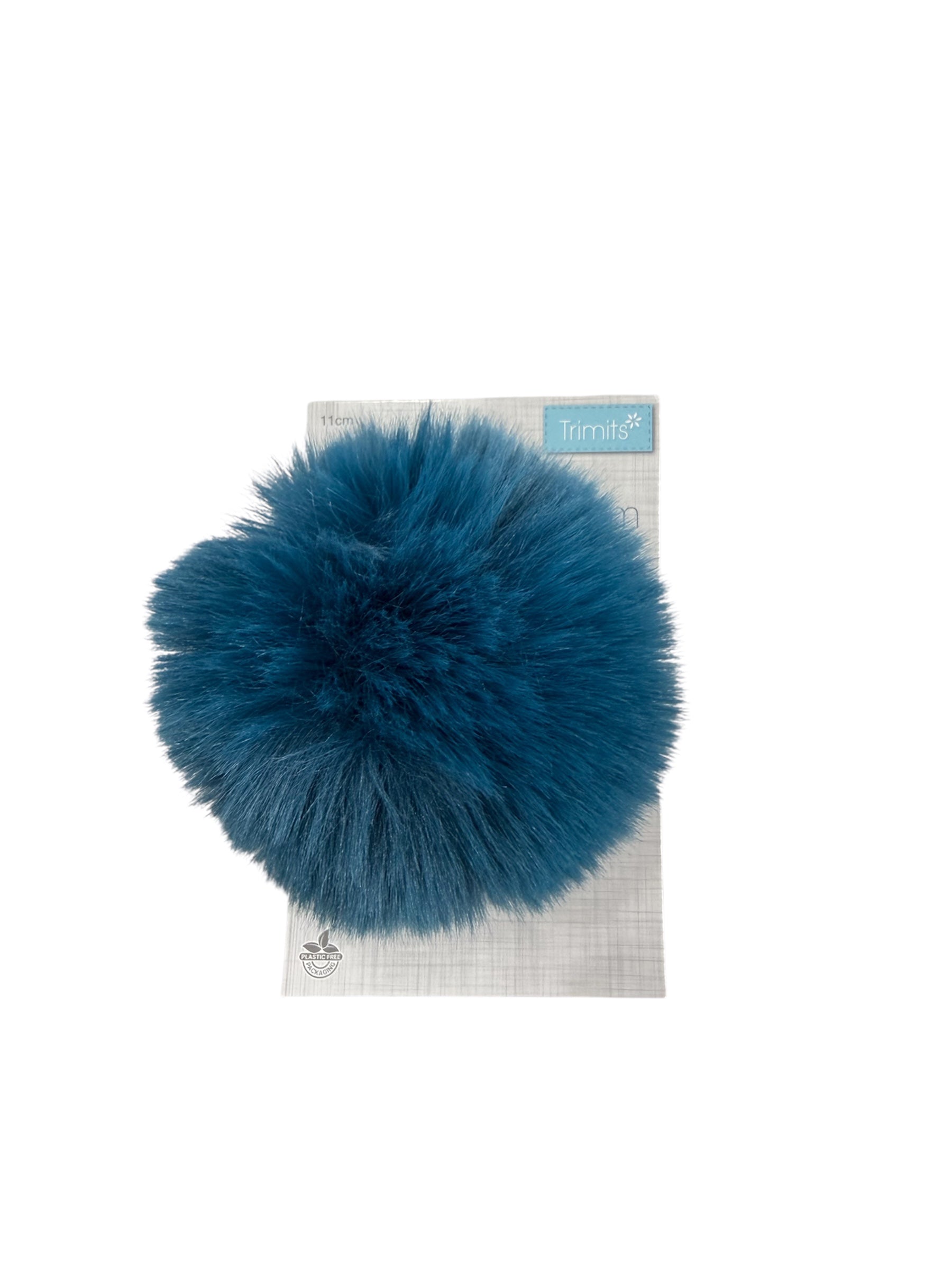 Trimits 11cm faux fur pompon in teal on a grey and white patterned backing.