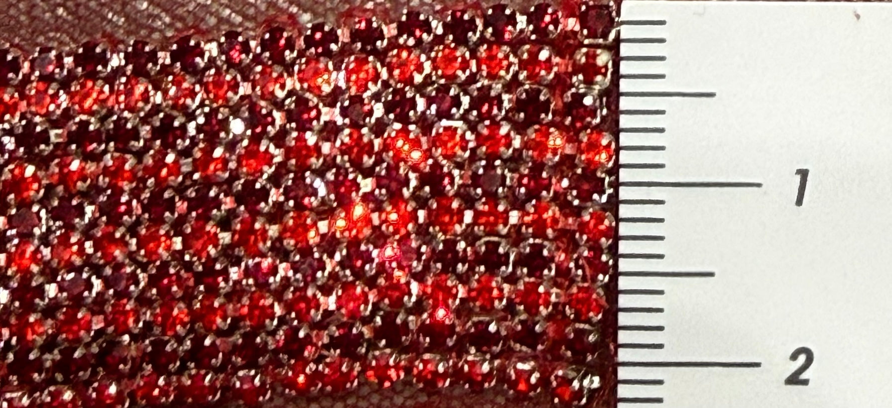Red hand-beaded gem tape with a textured surface.