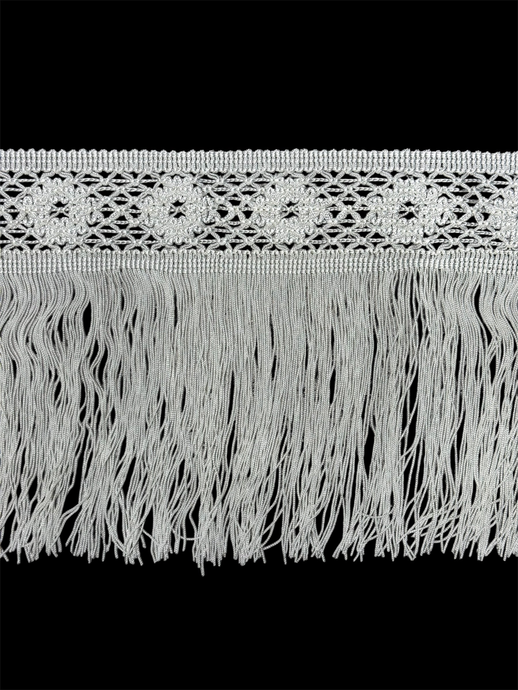White fringe trim with a decorative woven band.