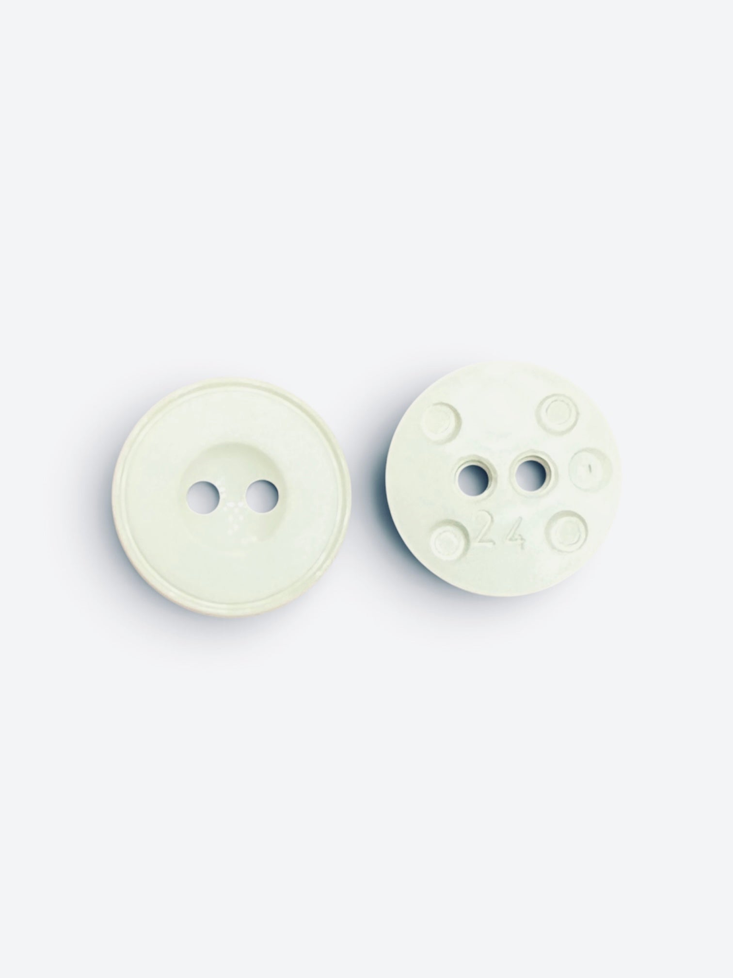 Two 15mm round flat white 2-hole sewing buttons showing front and back details.