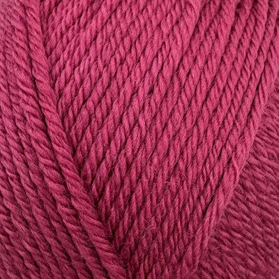 Close-up of Stylecraft Naturals Pure Wool DK yarn in a raspberry pink color showing stitch texture.