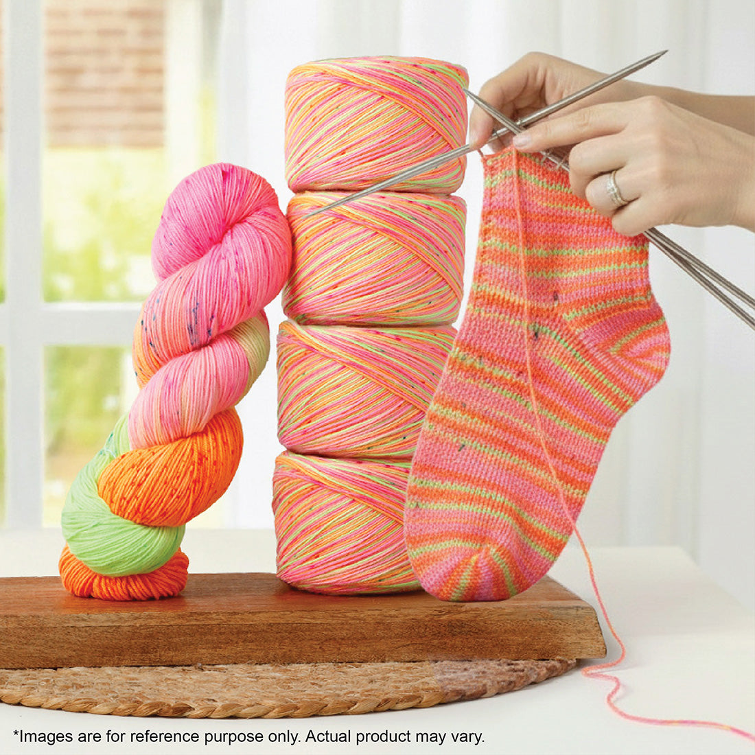 A hand-dyed variegated pink, orange, and green 100g Terra sock yarn skein and a knitted sock.