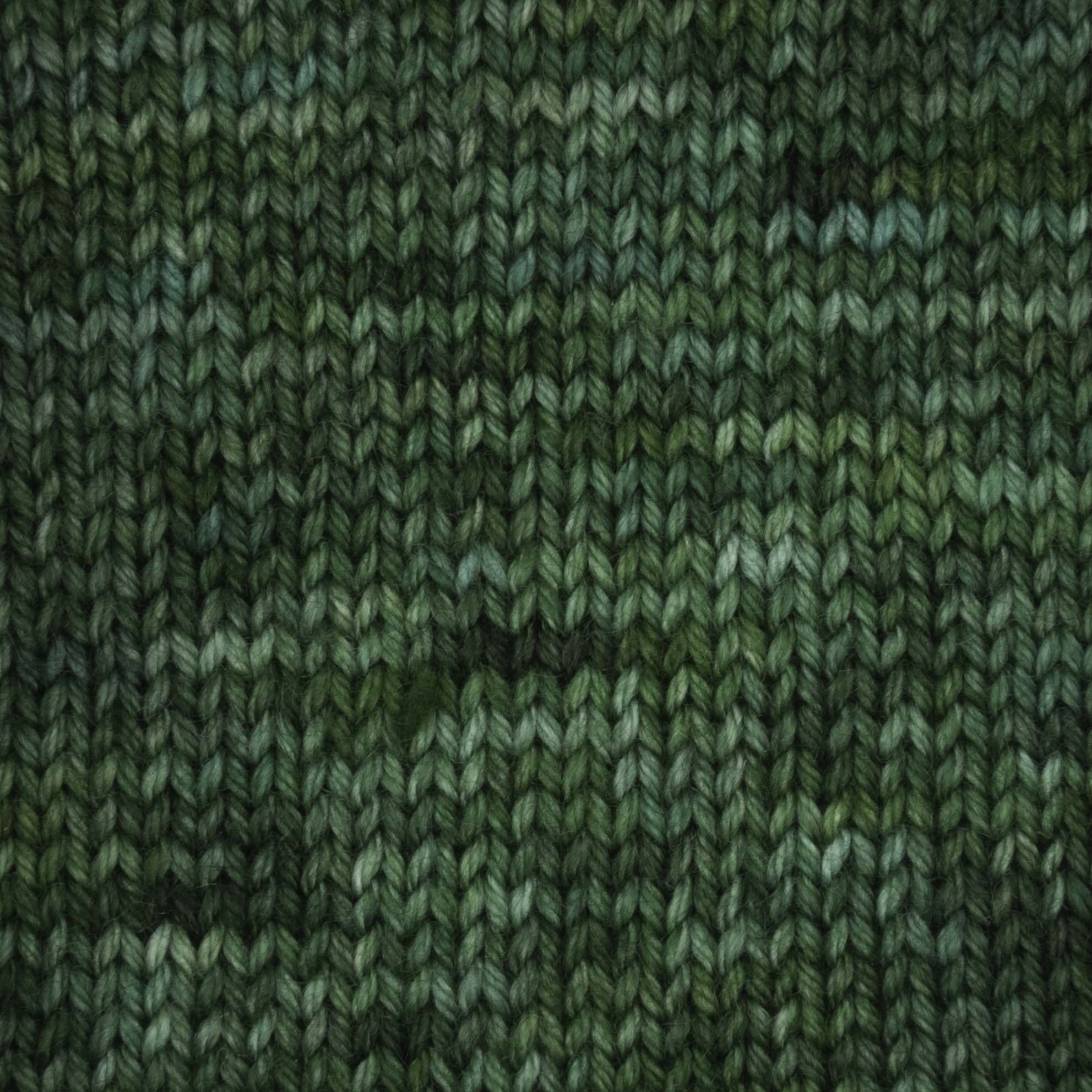 Close-up of a knitted swatch in Terra sock yarn, featuring variegated shades of forest green.