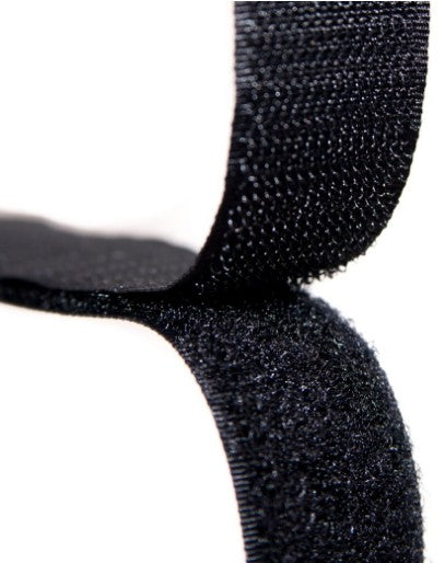 Close-up of black hook and loop tape being pulled apart.