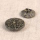 Two round, dark grey buttons with a speckled texture made from rice husk and polyester.