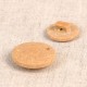 Two round, tan-colored buttons made from rice husk and polyester, showing front and back views.