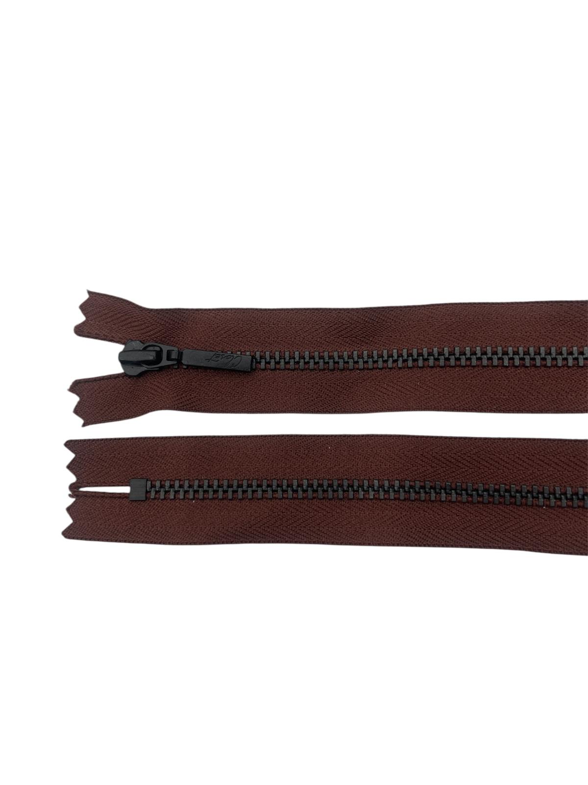 Two brown zippers with black metal teeth and sliders on a white background.