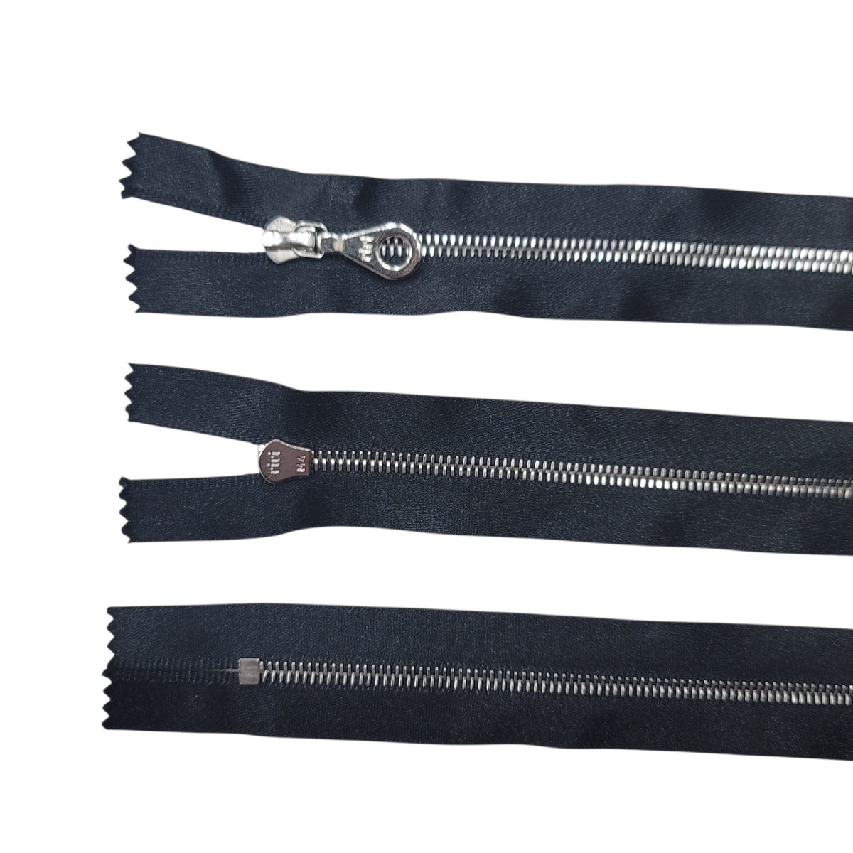 Three Riri M4 silver metal closed end zippers with black satin tape shown from different angles.