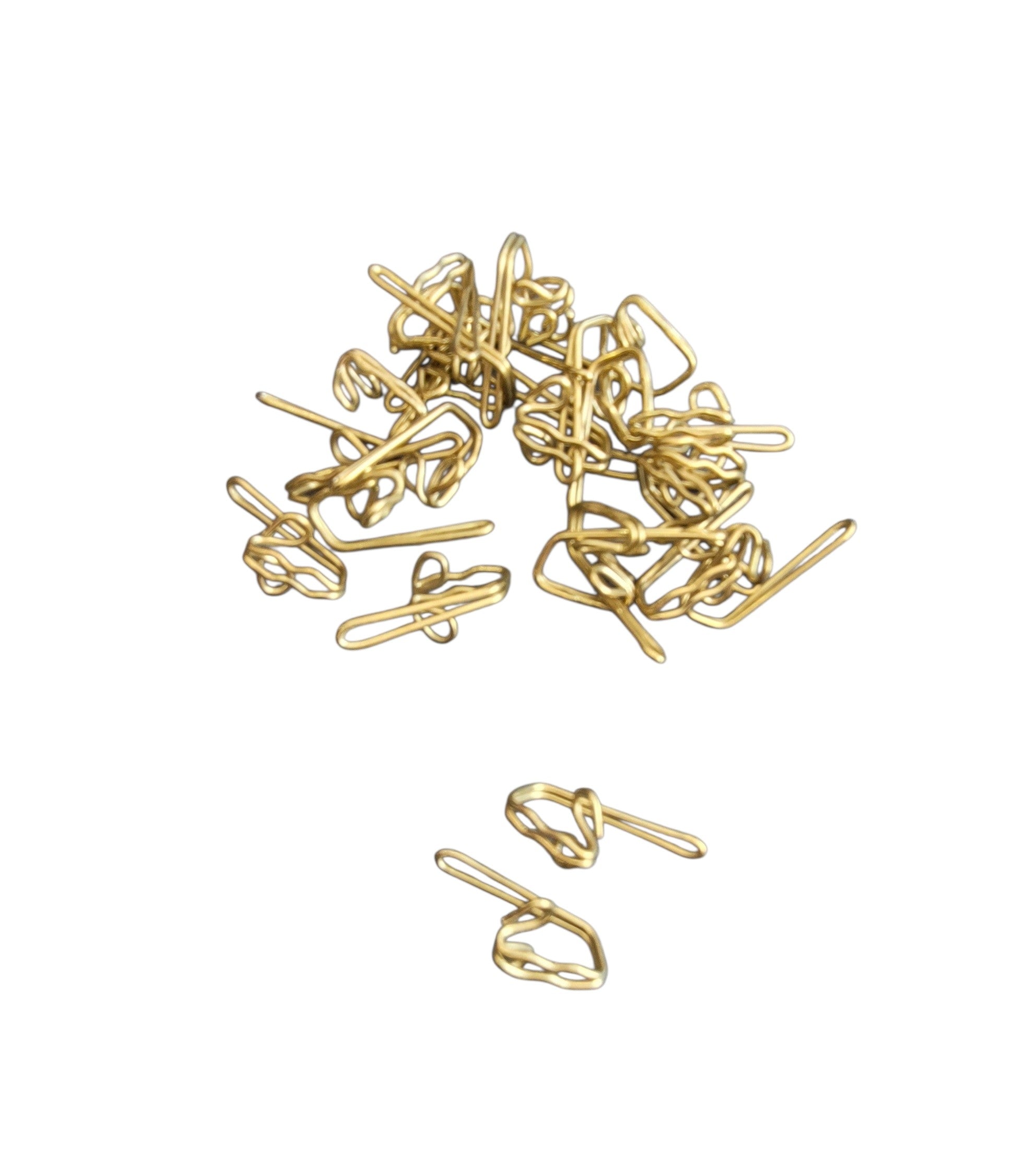 A pile of 25 gold-colored metal curtain hooks for heading tapes and tracks.